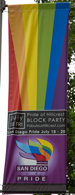Banner announcing the upcoming pride parade and events on a lamppost in the city